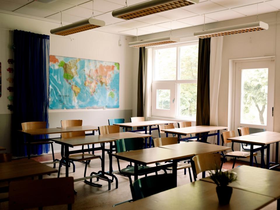 Desks and chairs arranged in classroom at high school