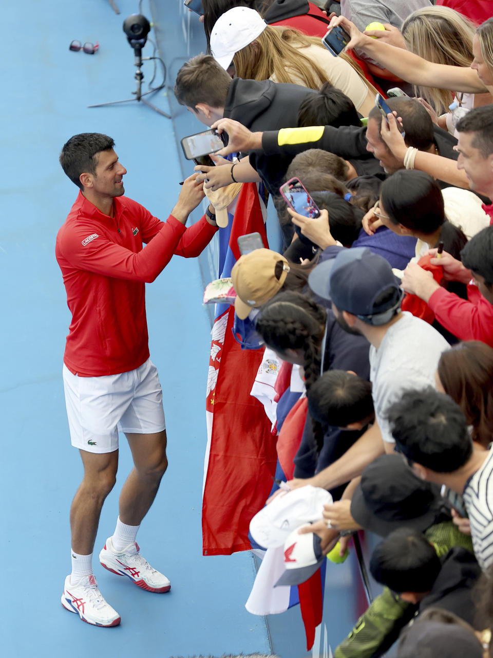 Serbia's Novak Djokovic signs autographs after defeating France's Quentin Halys during their Round of 16 match at the Adelaide International Tennis tournament in Adelaide, Australia, Thursday, Jan. 5, 2023. (AP Photo/Kelly Barnes)