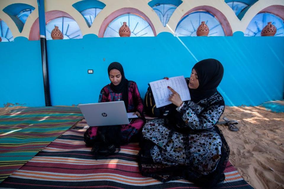 Hafsa Amberkab, right, and Fatma Addar, Nubian Egyptian women who compiled a dictionary, show off a Nubian lexical chart near Aswan in upper Egypt. <a href="https://www.gettyimages.com/detail/news-photo/hafsa-amberkab-and-fatma-addar-nubian-egyptian-women-who-news-photo/1210648292?adppopup=true" rel="nofollow noopener" target="_blank" data-ylk="slk:Khaled Desouki/AFP via Getty Images;elm:context_link;itc:0;sec:content-canvas" class="link ">Khaled Desouki/AFP via Getty Images</a>