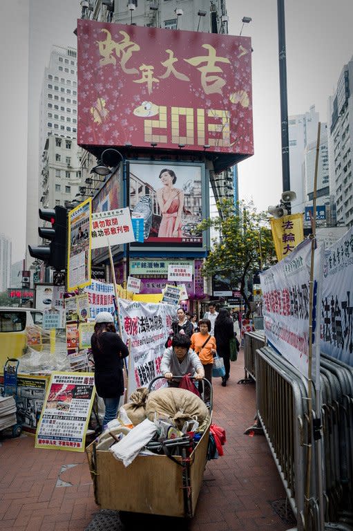 A woman pushes a loaded cart past a billboard set up for the Chinese New Year, in Hong Kong, on February 5, 2013. The lunar calendar is based on the cycles of the moon and associates each of the 12 years forming a rotating cycle with an animal -- with the snake assuming the sixth position out of the 12 animal signs