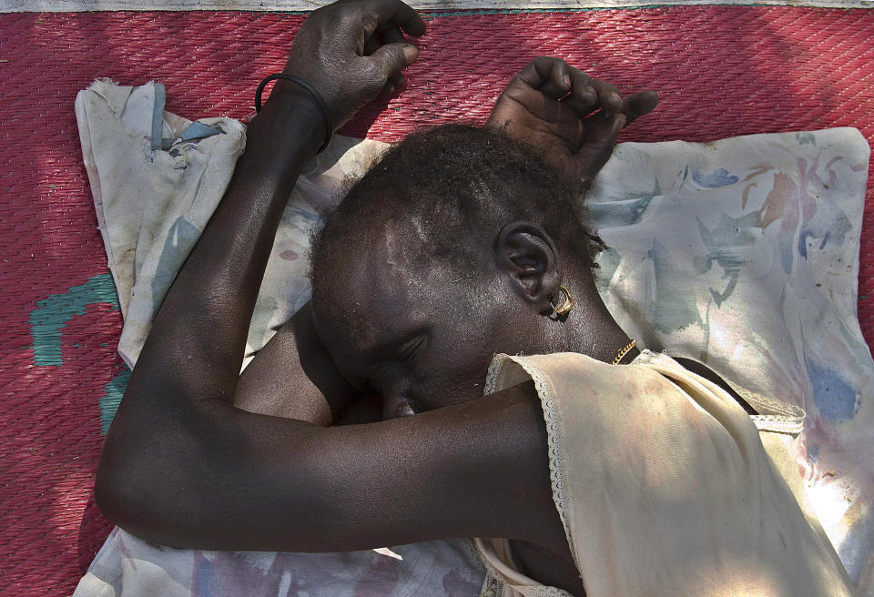 A South Sudanese woman sleeps on January 7, 2014 at the Ochaya Rhino refugee camp in the Arua District, about 495 kilometres north west of Uganda's capital Kampala.&nbsp;