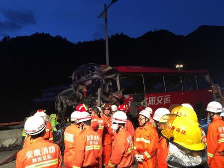 Firefighters work near the wreckage of a coach after it crashed into the wall of a tunnel along the Xi'an-Hanzhong expressway in Ankang, Shaanxi province, China August 11, 2017. REUTERS/Stringer