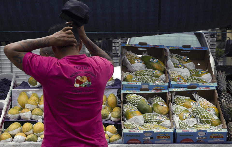 A man reacts at a fruit stall at the street market in Sao Paulo, Brazil, on August 25, 2022. (Photo by Miguel SCHINCARIOL/AFP)