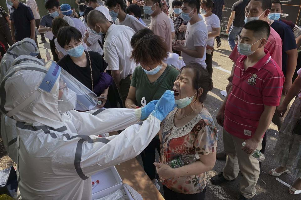 A worker in a protective suits tests people for Covid-19 (Getty Images)