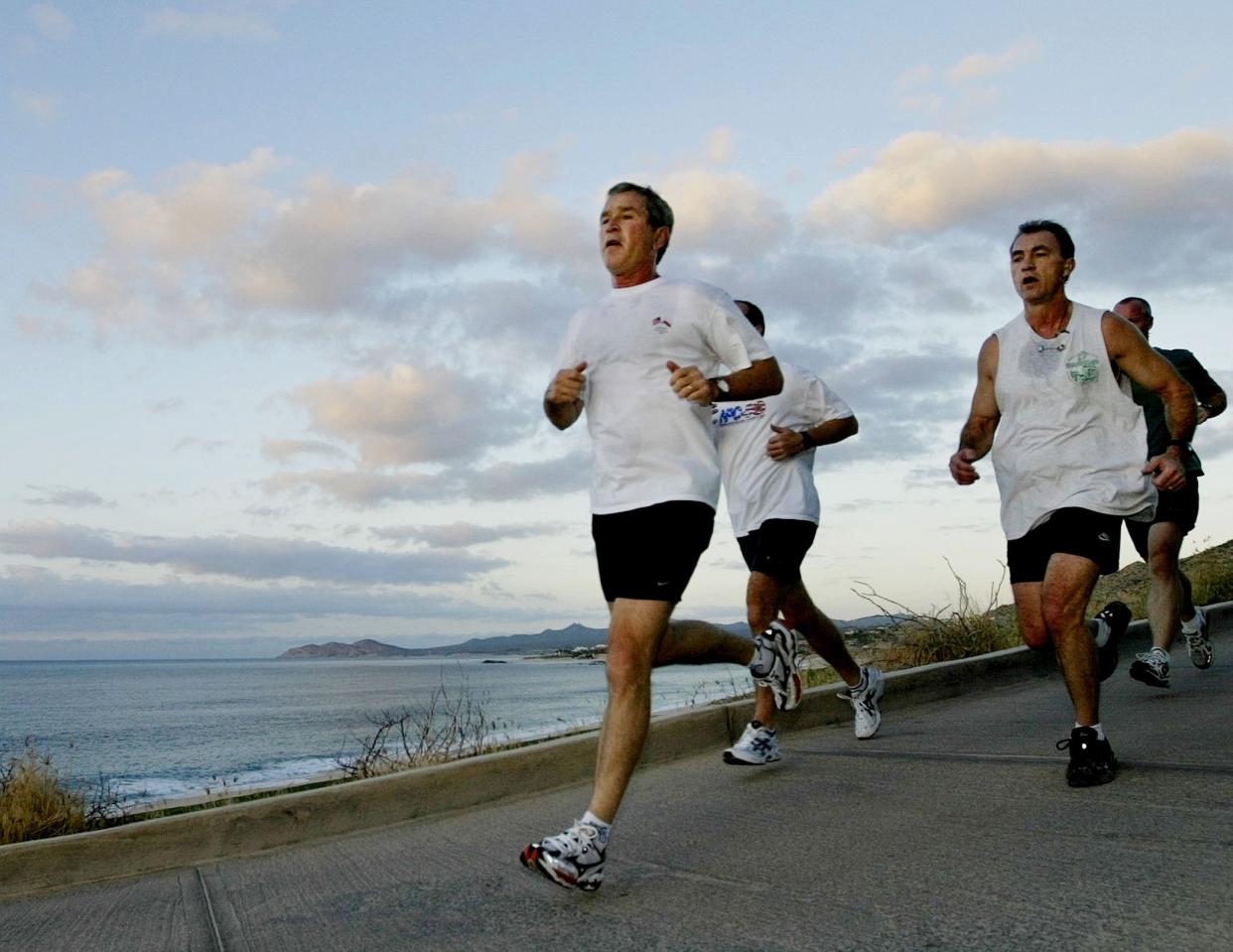 In 2002, then-President George W. Bush jogs with U.S. Secret Service agents during the APEC Leaders’ annual meetings in Los Cabos, Mexico. (Photo: Larry Downing/Reuters)
