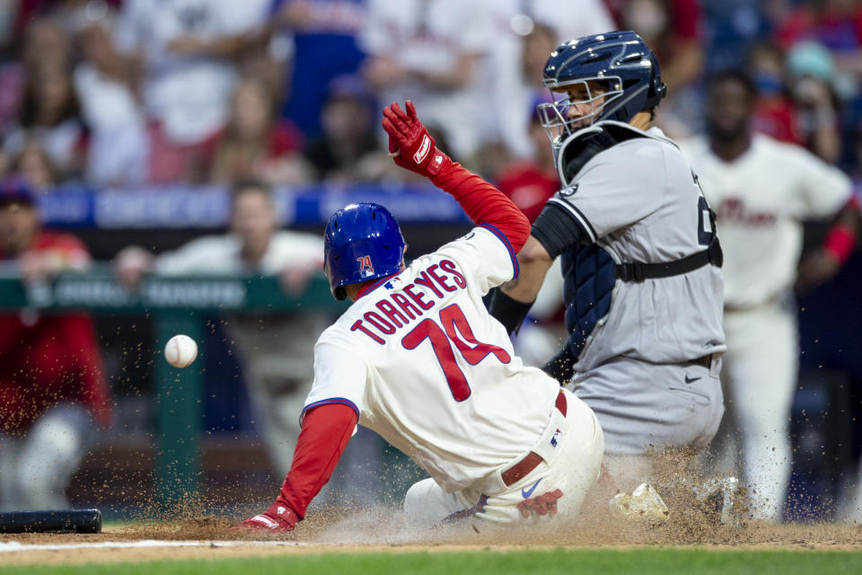 Philadelphia Phillies' Ronald Torreyes (74) is safe at home on an RBI-single by Jean Segura before New York Yankees catcher Gary Sanchez, right, can make the catch during the 10th inning of a baseball game, Saturday, June 12, 2021, in Philadelphia. (AP Photo/Laurence Kesterson)