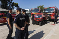 Romanian firefighters stand near to fire engines during a ceremony, in Athens, on Saturday, July 2, 2022. Twenty eight Romanian firefighters, the first of more than 200 firefighters from other European countries that will help their Greek colleagues in fighting wildfires, were welcomed by Climate Crisis and Civil Protection Minister Christos Stylianides and the leadership of Greece's Fire Service. (AP Photo/Yorgos Karahalis)