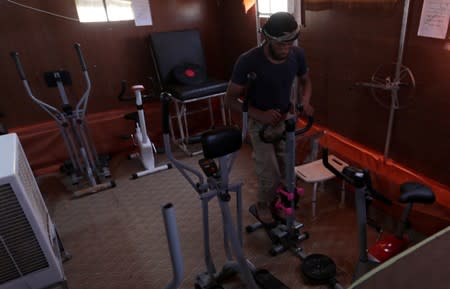 A displaced Syrian refugee attends a session at a physiotherapy clinic inside a large tent in the border village of Shamarin