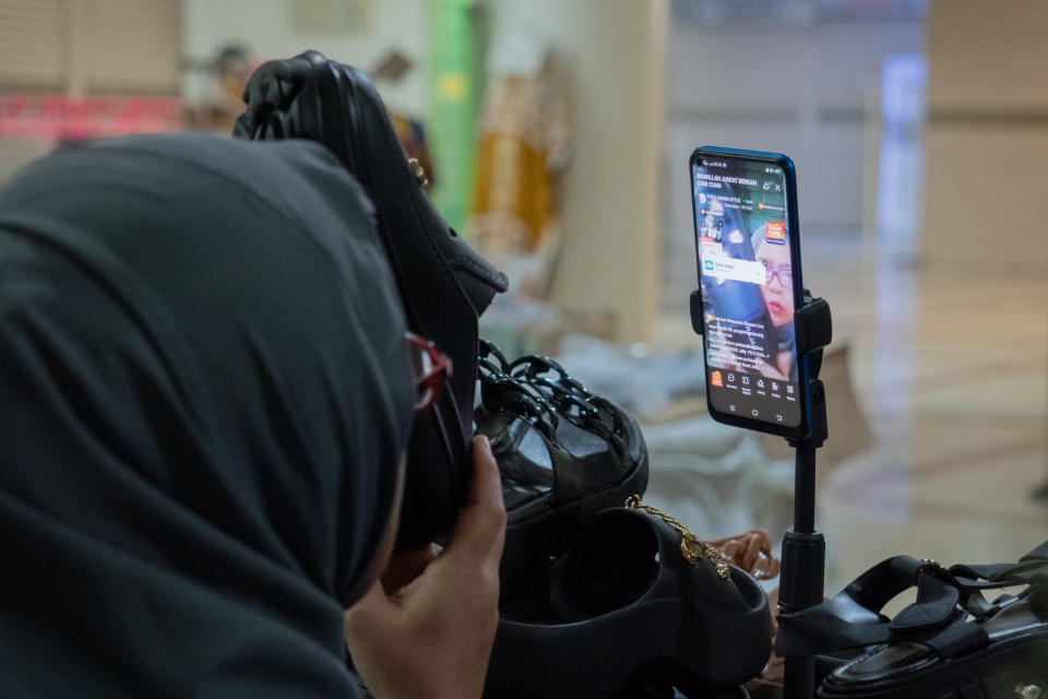 A trader is conducting live sales via streaming at Tanah Abang Market, Jakarta, Indonesia, on September 22, 2023. The lack of buyers in Southeast Asia's largest textile and garment market is attributed to the increasing shift towards e-commerce platforms, particularly TikTok Shop. Traders lament a sales decline exceeding 50 percent over the past four months. Meanwhile, the Minister of Trade of the Republic of Indonesia, Zulkifli Hasan, stated that measures will be taken to regulate online sales on TikTok Shop to protect the interests of Micro, Small, and Medium Enterprises (MSMEs). (Photo by Kevin Herbian/NurPhoto via Getty Images)