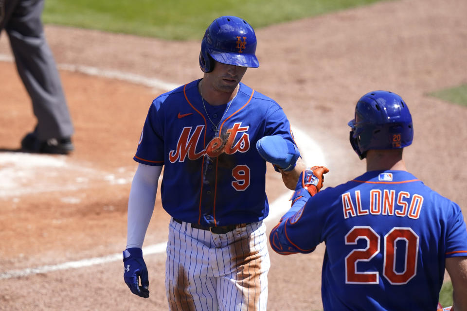 Brandon Nimmo (9) de los Mets de Nueva York es recibido por Pete Alonso (20) después de anotar durante la primera entrada de un juego de béisbol de entrenamiento de primavera contra los Cardenales de San Luis, el domingo 14 de marzo de 2021, en Port St. Lucie, Florida (Foto AP/Lynne Sladky)