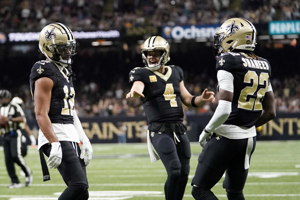 New Orleans Saints wide receiver Chris Olave (12) celebrates his touchdown catch with quarterback Derek Carr (4) and wide receiver Rashid Shaheed (22) during the first half of an NFL football game in New Orleans, Sunday, Nov. 5, 2023. (AP Photo/Gerald Herbert)