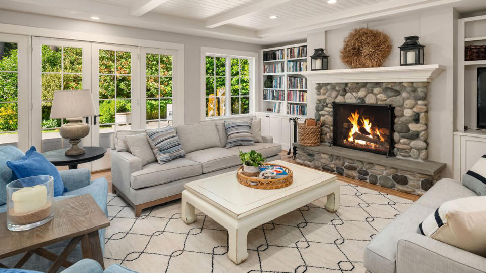 A raised-hearth river-rock fireplace adds rustic charm to the formal living room.