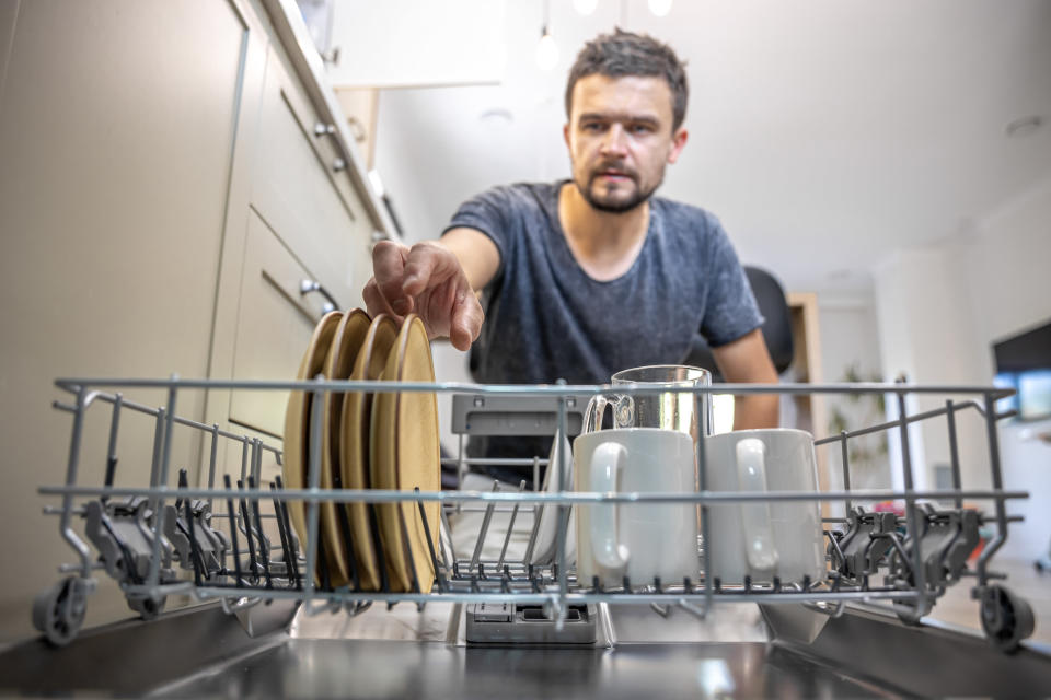 man taking dishes out of the dishwasher