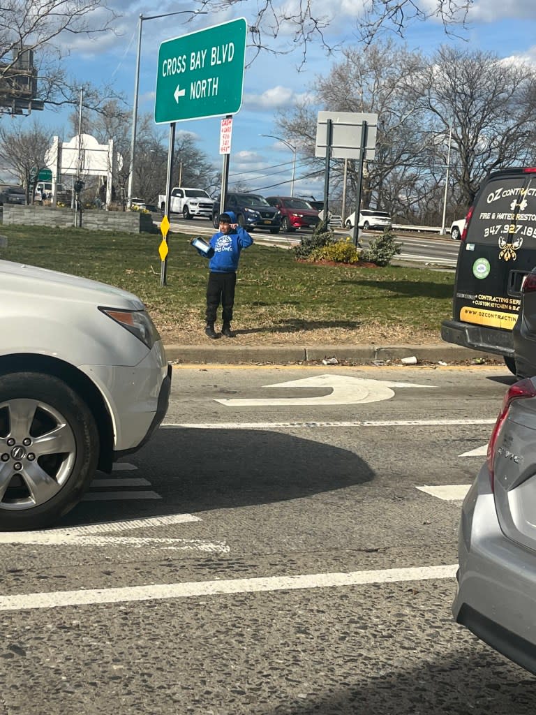 Migrant boy selling candy near the Cross Bay Boulevard entrance to the Belt Parkway in Queens.