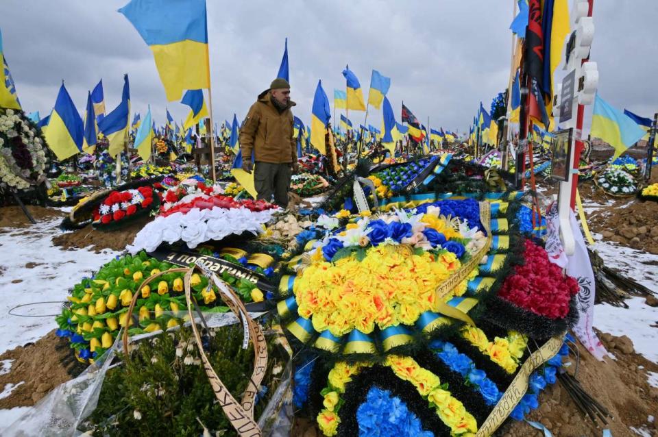 Un homme marche parmi les tombes de soldats ukrainiens dans « l’allée de la gloire » d’un cimetière de Kharkiv, en Ukraine, le 16 février 2023.