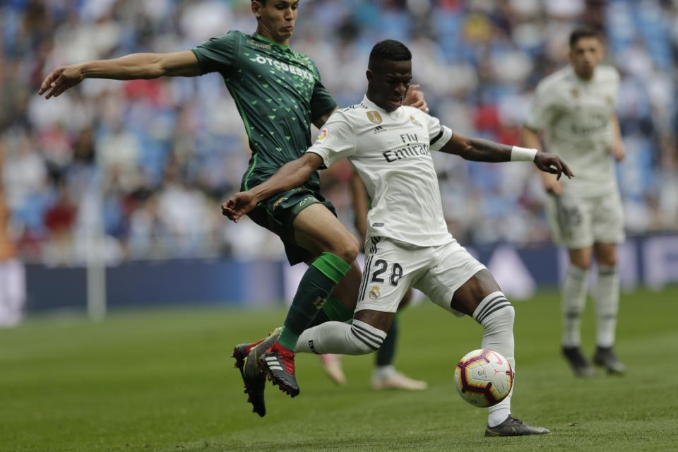 Real Madrid's Vinicius Junior, right, duels for the ball against Betis player Aissa Mandi during a Spanish La Liga soccer match at the Santiago Bernabeu stadium in Madrid, Spain, Sunday, May 19, 2019. (AP Photo/Bernat Armangue)