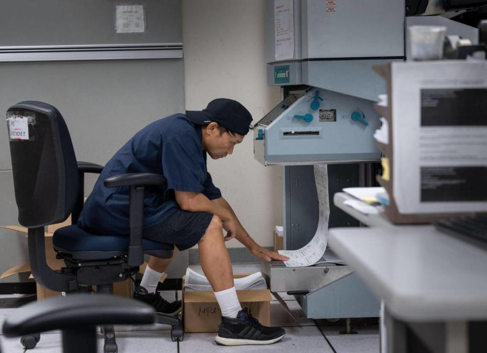 IT technician Erwin Corspuz prepares printed pay paychecks for California state workers at the state controller’s printing facility on Aug. 24.