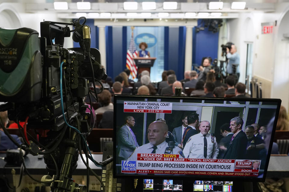 A television broadcasts news of former President Donald Trump's Manhattan courthouse appearance is seen on a video monitor as White House press secretary Karine Jean-Pierre speaks during a press briefing at the White House, Tuesday, April 4, 2023, in Washington. (AP Photo/Patrick Semansky)