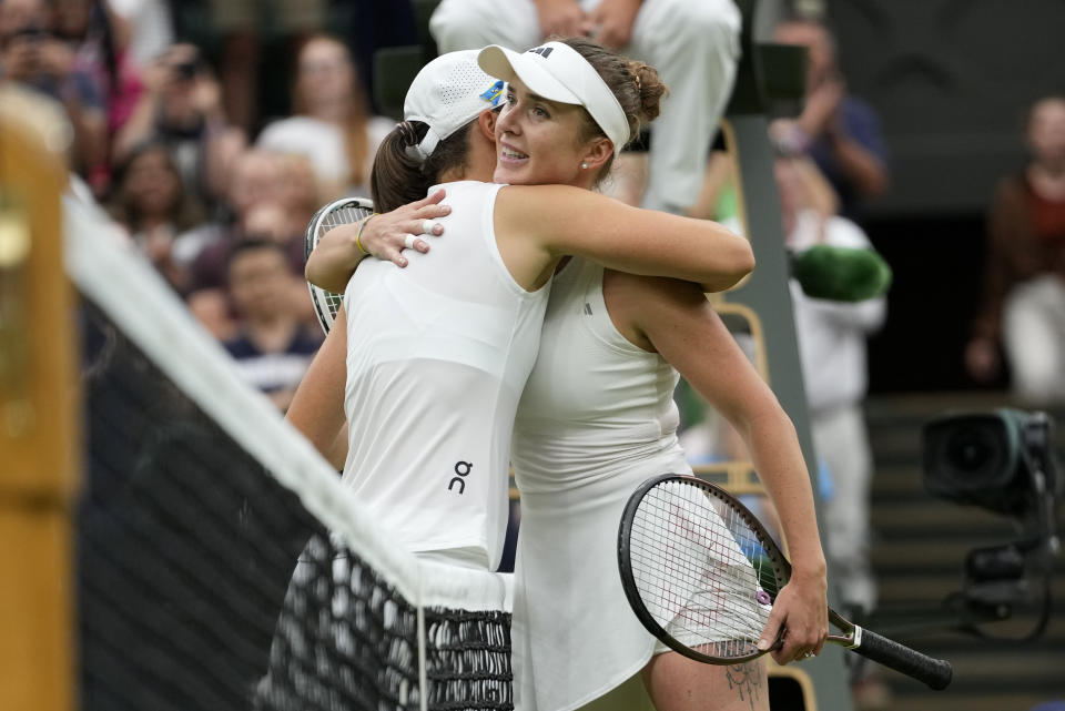 Ukraine's Elina Svitolina, right greets Poland's Iga Swiatek at the net after beating her to win their women's singles match on day nine of the Wimbledon tennis championships in London, Tuesday, July 11, 2023. (AP Photo/Kirsty Wigglesworth)