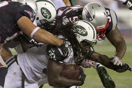 New York Jets Chris Ivory (33) is brought down by New England Patriots Rob Ninkovich (L) and Brandon Spikes during their NFL AFC East football game in Foxborough, Massachusetts, September 12, 2013. REUTERS/Dominick Reuter