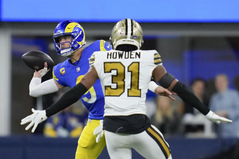 Los Angeles Rams quarterback Matthew Stafford (9) throws behind New Orleans Saints safety Jordan Howden (31) during the first half of an NFL football game Thursday, Dec. 21, 2023, in Inglewood, Calif. (AP Photo/Ashley Landis)