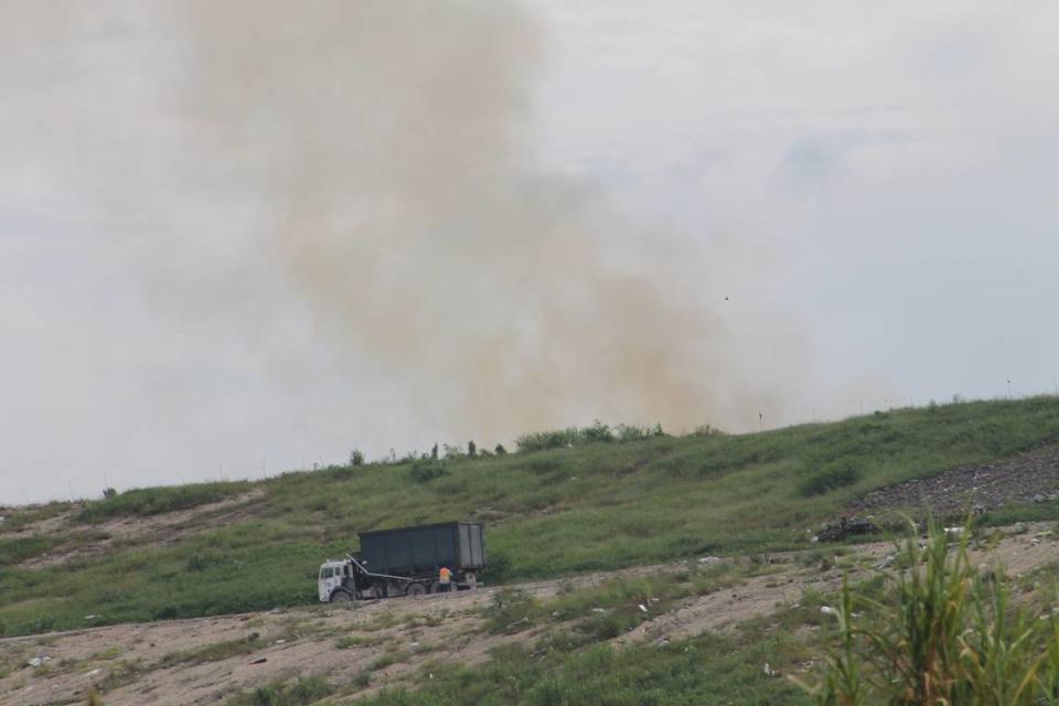 A garbage truck drives past a fire near the top of the south Miami-Dade County landfill Friday, Sept. 25, 2020.