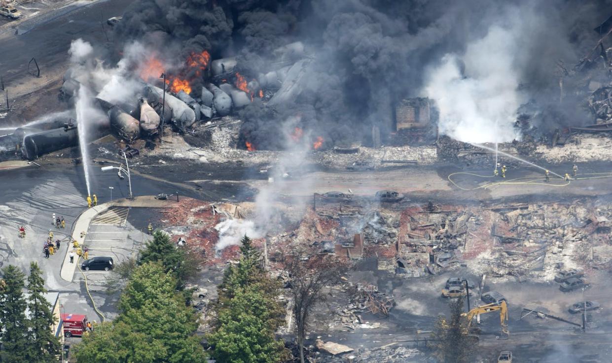 Smoke rises from destroyed railway cars that were carrying crude oil after derailing in downtown Lac-Mégantic, Que., the day after the derailment and explosion killed 47 people. THE CANADIAN PRESS/Paul Chiasson