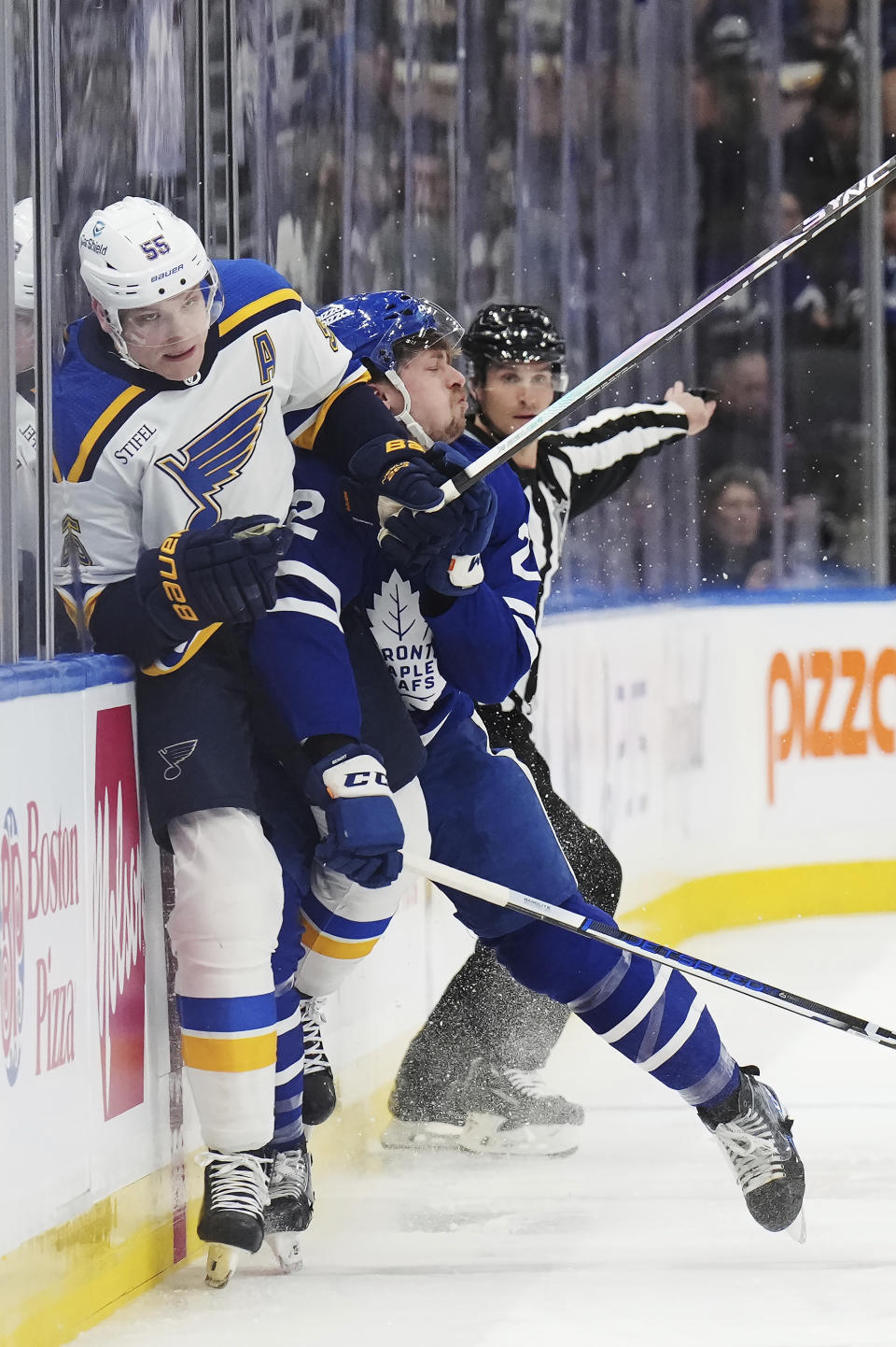 St. Louis Blues defenseman Colton Parayko (55) is checked by Toronto Maple Leafs defenseman Simon Benoit (2) during the first period of an NHL hockey game, Tuesday, Feb. 13, 2024 in Toronto. (Nathan Denette/The Canadian Press via AP)