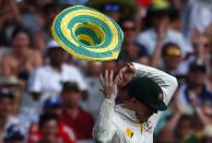 RNPS YEAR END 2014 - BEST OF SPORT ODDLY A hat that blew onto the field, is blown off the head of Australia's Chris Rogers after he put it on during the first day of the fourth Ashes cricket test against England, at the Melbourne cricket ground, in this December 26, 2013 file photo. REUTERS/David Gray/Files (AUSTRALIA - Tags: SPORT CRICKET TPX IMAGES OF THE DAY)