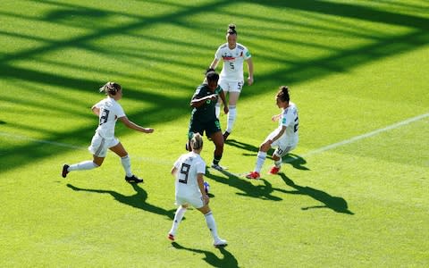 Nigeria's Desire Oparanozie in action surrounded by Germany players - Credit: Reuters