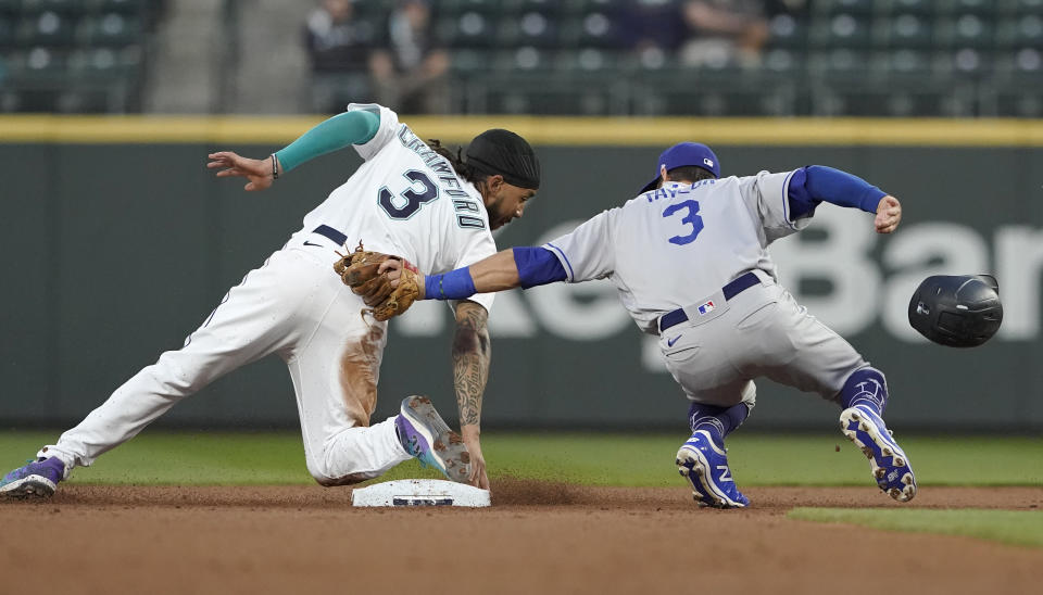 Los Angeles Dodgers second baseman Chris Taylor, right, tries to put a tag on Seattle Mariners' J.P. Crawford, left, as Crawford attempts to steal second during the second inning of a baseball game, Monday, April 19, 2021, in Seattle. Crawford was called out on the play. (AP Photo/Ted S. Warren)