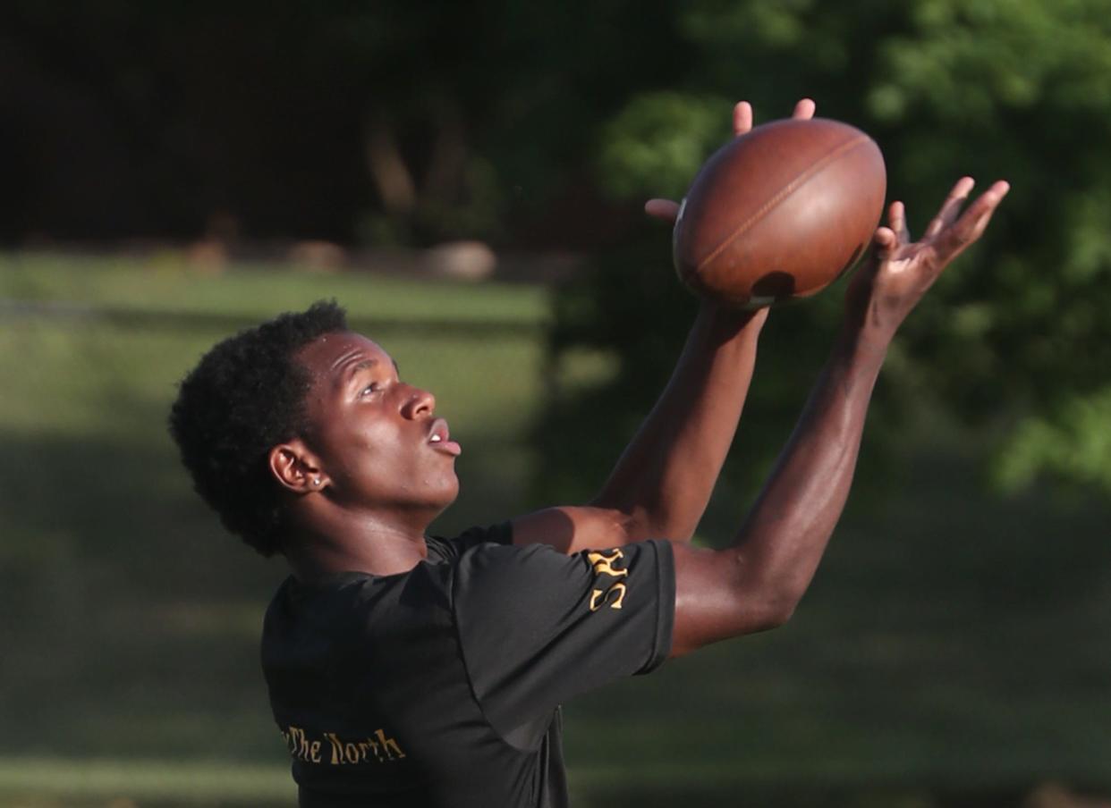 North High School football player Zi'Velle Thomas catches a pass during the first annual Sonil Haslam Community Youth Football Camp at North High School on Wednesday.