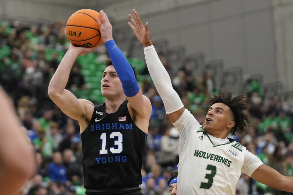 BYU guard Alex Barcello (13) shoots as Utah Valley guard Blaze Nield (3) defends in the first half during an NCAA college basketball game Wednesday, Dec. 1, 2021, in Orem, Utah. (AP Photo/Rick Bowmer)