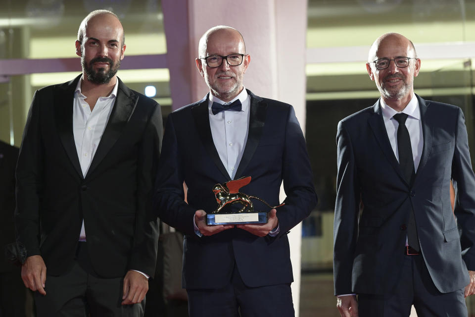 Disney's Marketing Director for Italy, Davide Romani, center, holds the Golden Lion Best Film award for "Nomadland", at the closing ceremony of 77th edition of the Venice Film Festival, in Venice, Italy, Saturday Sept. 12, 2020. Director Chloe Zhao’s “Nomadland,” a recession-era road trip drama starring Frances McDormand, has won the Golden Lion for best film at the Venice Film Festival, held against the backdrop of the coronavirus pandemic. (Gian Mattia D'Alberto/LaPresse via AP)