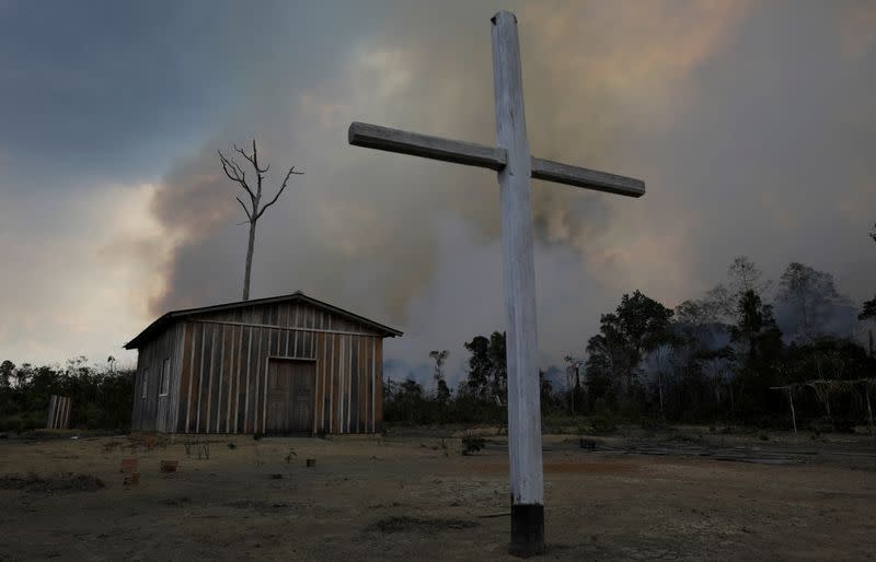 Catholic church is pictured as fire burns tract of Amazon jungle being cleared by loggers and farmers near Porto Velho