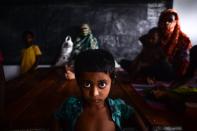 A young resident rests with others in a shelter ahead of the expected landfall of cyclone Amphan in Dacope of Khulna district on May 20, 2020. - Several million people were taking shelter and praying for the best on Wednesday as the Bay of Bengal's fiercest cyclone in decades roared towards Bangladesh and eastern India, with forecasts of a potentially devastating and deadly storm surge. Authorities have scrambled to evacuate low lying areas in the path of Amphan, which is only the second "super cyclone" to form in the northeastern Indian Ocean since records began. (Photo by Munir Uz zaman / AFP) (Photo by MUNIR UZ ZAMAN/AFP via Getty Images)