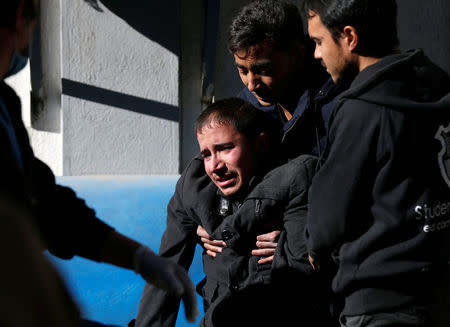 An Afghan man mourns inside a hospital compound after a suicide attack in Kabul, Afghanistan December 28, 2017. REUTERS/Mohammad Ismail