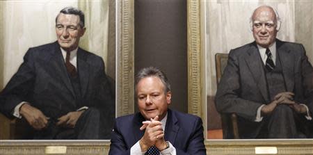 Bank of Canada Governor Stephen Poloz, sitting in front of portraits of former governors James Coyne (L) and Louis Rasminsky, takes part in an interview with Reuters in Ottawa December 17, 2013. REUTERS/Chris Wattie