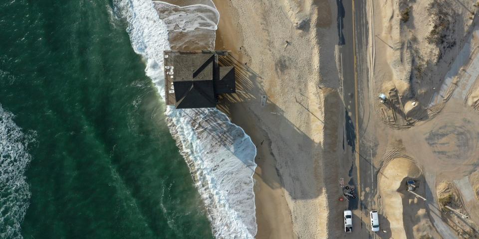 Atlantic Ocean waves encroach upon a beachfront house on the Outer Banks of North Carolina in January 2023.