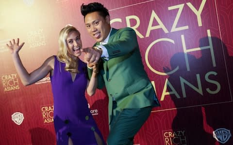 Director John Chu and his wife Kristin Hodge pose for photographers as they arrive for the red carpet screening of the movie "Crazy Rich Asians" on Tuesday - Credit:  Don Wong/AP