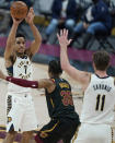 Indiana Pacers' Malcolm Brogdon (7) passes the ball over Cleveland Cavaliers' Isaac Okoro (35) to Domantas Sabonis (11) during the second half of an NBA basketball game Wednesday, March 3, 2021, in Cleveland. (AP Photo/Tony Dejak)