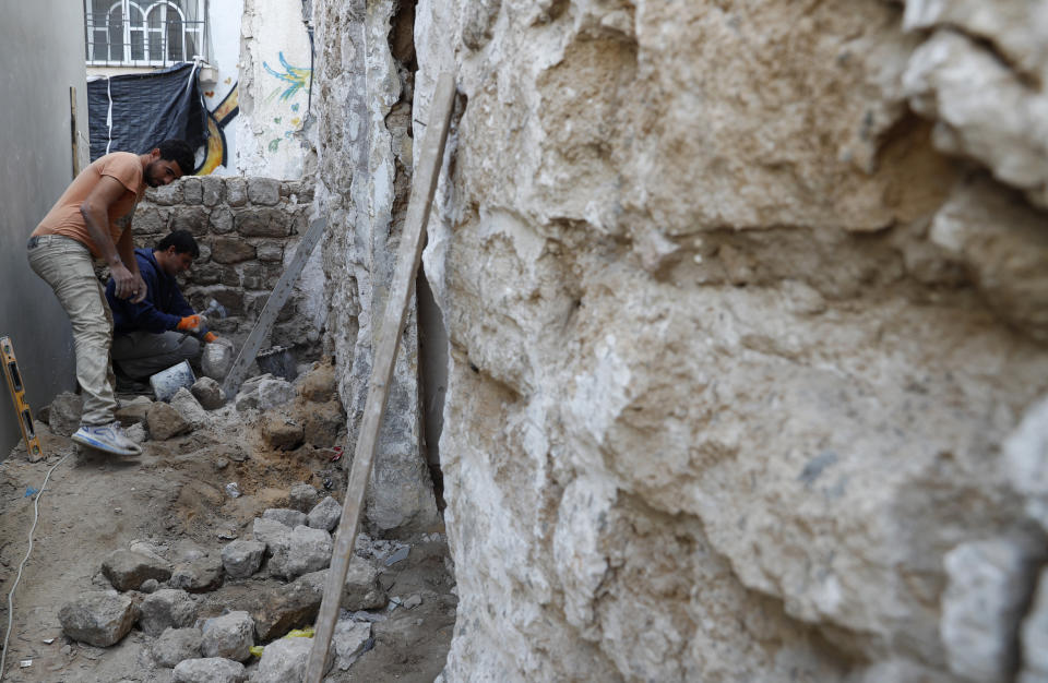 Workers renovate the long-abandoned 200-year-old Ghussein palace, in the old quarter of Gaza City, Monday, Dec. 14, 2020. Less than 200 of these old houses are still partly or entirely standing, according to officials and they are threatened by neglect, decaying and urban sprawl. (AP Photo/Adel Hana)