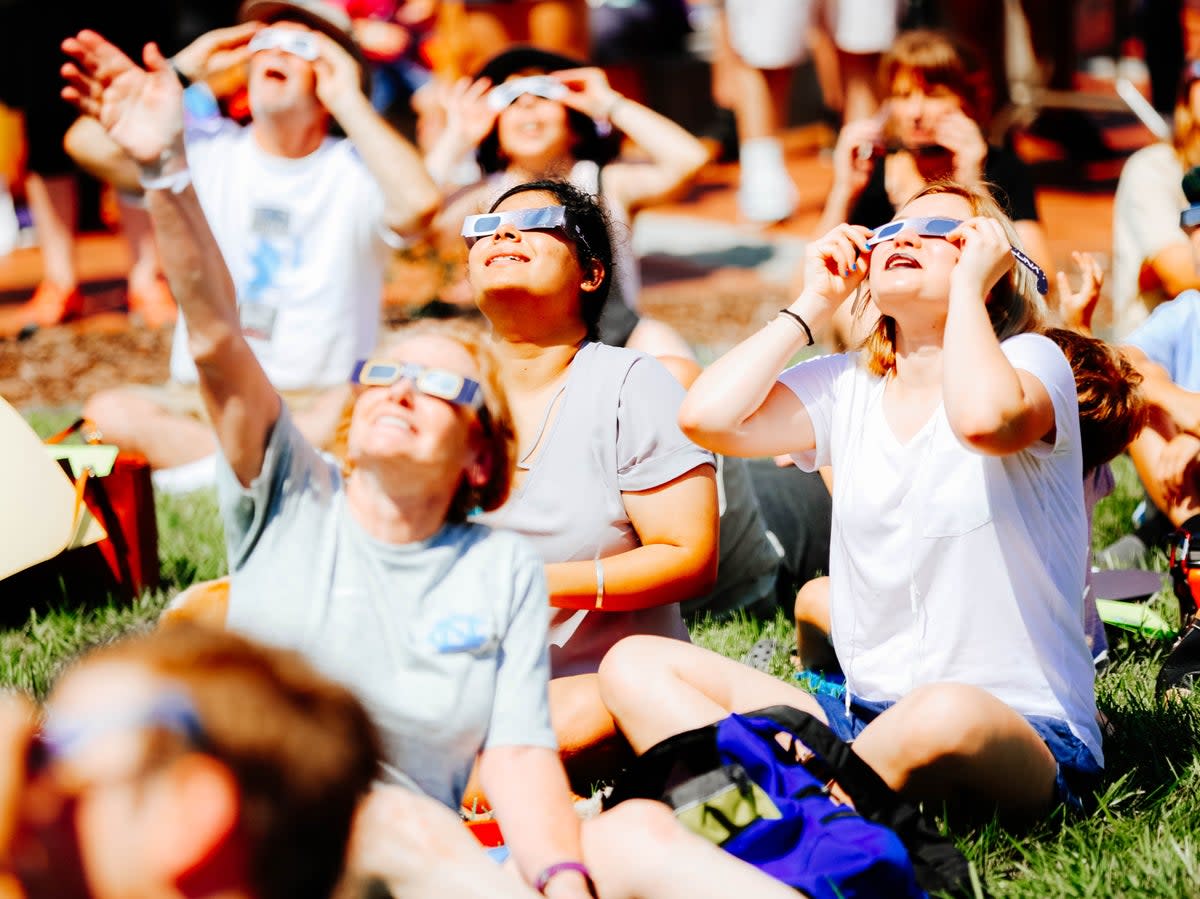 Solar eclipse spectators sitting in the park wearing the proper eclipse glasses (Getty Images)