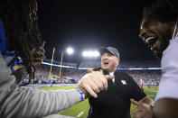 Kentucky head coach Mark Stoops, center, slaps hands with rapper Waka Flocka Flame, left, after winning an NCAA college football game against Florida in Lexington, Ky., Saturday, Oct. 2, 2021. (AP Photo/Michael Clubb)