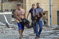 A wounded woman is evacuated after a massive explosion in Beirut, Lebanon, Tuesday, Aug. 4, 2020. (AP Photo/Hassan Ammar)