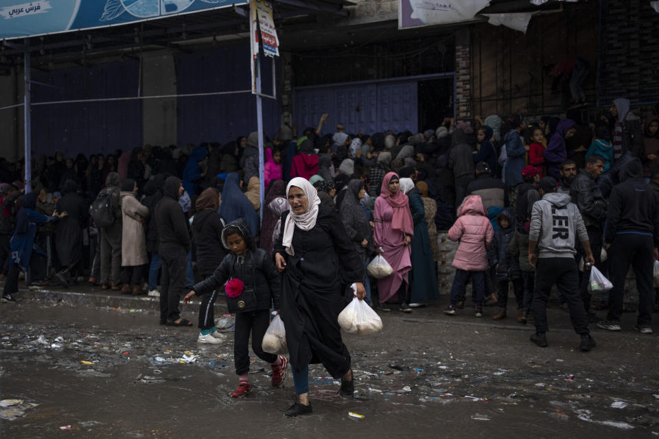 Palestinian crowds struggle to buy bread from a bakery in Rafah, Gaza Strip, Sunday, Feb. 18, 2024. International aid agencies say Gaza is suffering from shortages of food, medicine and other basic supplies as a result of the war between Israel and Hamas. (AP Photo/Fatima Shbair)