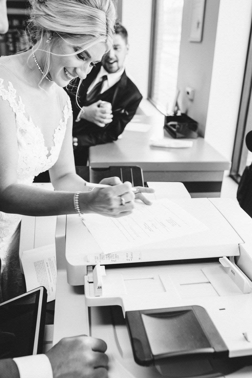 Jeanna Trotman, who grew up in Sterling Heights and recently returned to work as a sports reporter at WXYZ-TV, signs her husband Zach's contract as a witness with the Pittsburgh Penguins at a FedEx Kinko's in Detroit on their wedding day July 1, 2017.