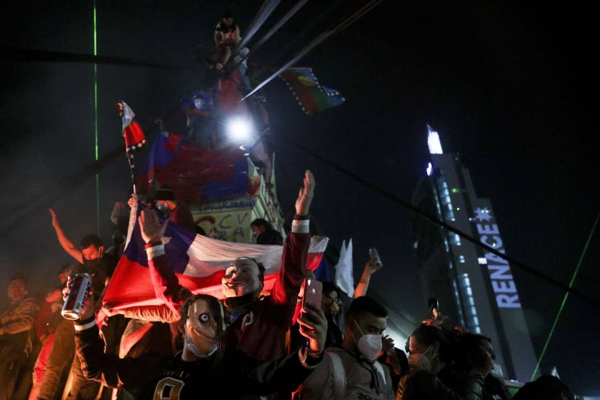 People gather at Plaza Italia on the day Chileans voted in a referendum to decide whether the country should replace its 40-year-old constitution, written during the dictatorship of Gen. Augusto Pinochet, in Santiago, Chile, Sunday, Oct. 25, 2020. (AP Photo/Esteban Felix)