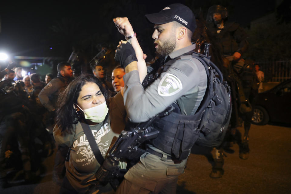 A Palestinian woman scuffles with Israeli border police officer during a protest against the planned evictions of Palestinian families in the Sheikh Jarrah neighborhood of east Jerusalem, Tuesday, May 4, 2021. (AP Photo/Mahmoud Illean)