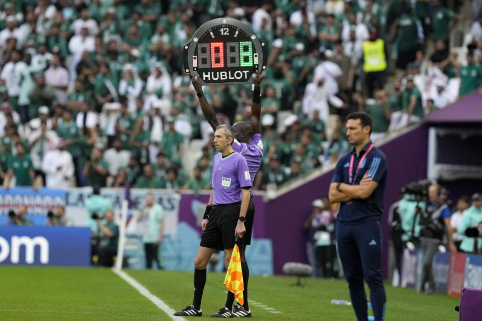 The referee assistant shows 8 minutes overtime during the World Cup group C soccer match between Argentina and Saudi Arabia at the Lusail Stadium in Lusail, Qatar, Tuesday, Nov. 22, 2022. (AP Photo/Natacha Pisarenko)